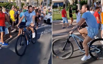 Conor McGregor steals attention away from Bugatti as he cycles past it