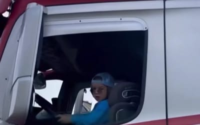 Four-year-old drives an 18-wheeler truck with a booster seat