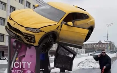 Lamborghini Urus somehow stuck on top of bus shelter and no one can work out why and if it’s even real