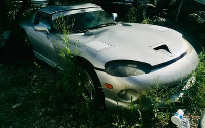 Abandoned Dodge Viper in New Jersey parking lot has become one with the vegetation and it's a sight no American car lover wants to see