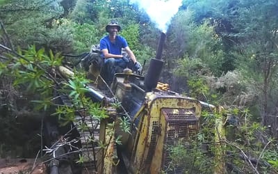 Man inspecting old Bulldozer that broke down in forest 15 years ago finds something bad happens when engine starts