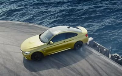 BMW drifts M4 across an aircraft carrier for an ad, sparking debates on authenticity