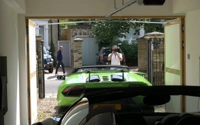 Man opens his garage doors to reveal his Lamborghini and Ferrari to capture reactions of people walking by