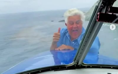 Jay Leno pops out of nose of Grumman HU-16 Albatross airplane flying over the Pacific Ocean