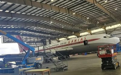 Sad fate of John Travolta's iconic Qantas Boeing 707 with its tail rotting away in abandoned warehouse's parking lot