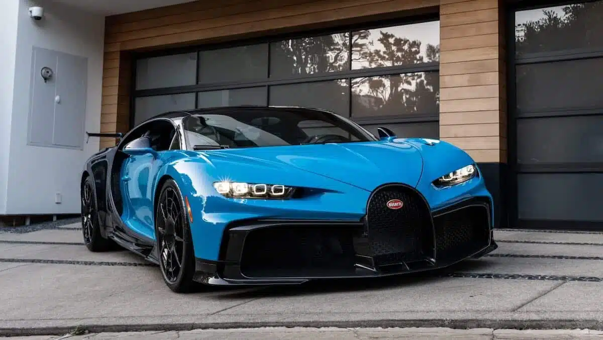 The two-tone Lake Blue and Bugatti Light Blue Sport is parked in front of a garage.