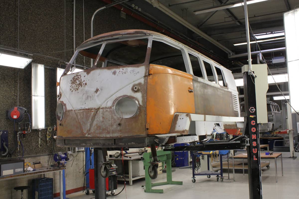 VW kombi campervan being worked on in a mechanic garage.