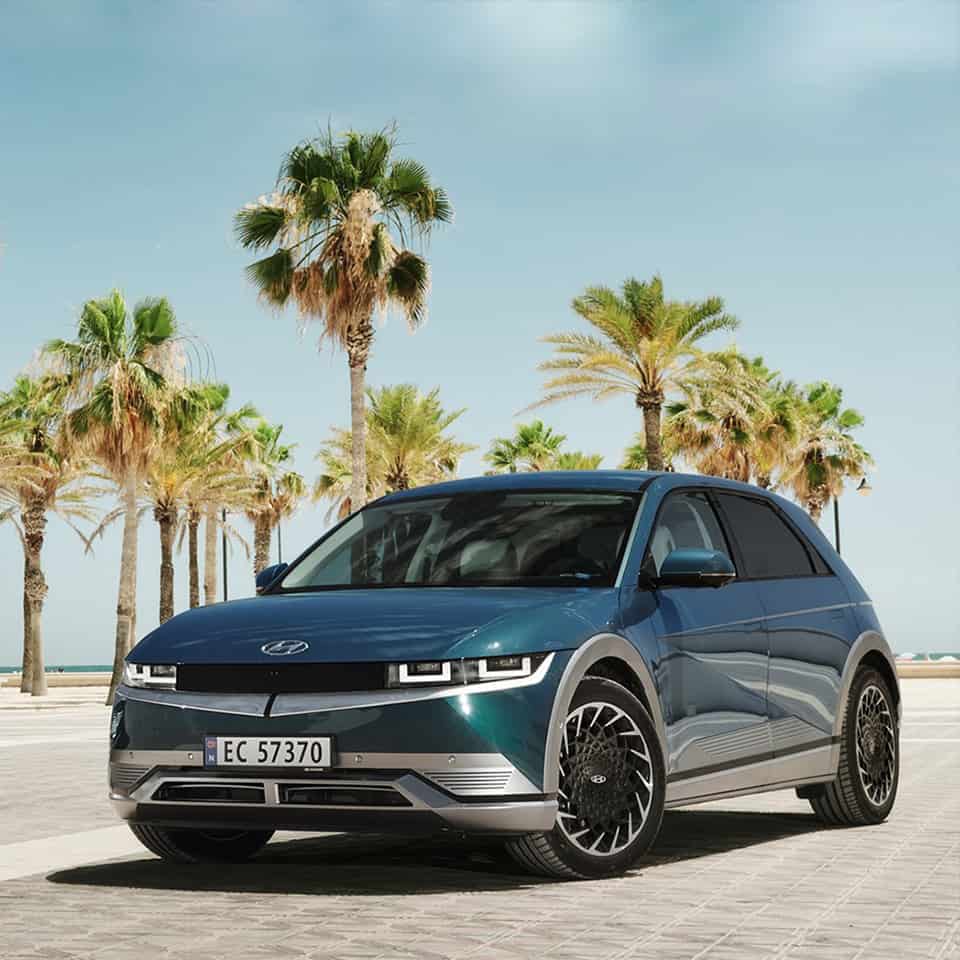 Hyundai Ioniq 5 in Digital Teal with palm trees in the background