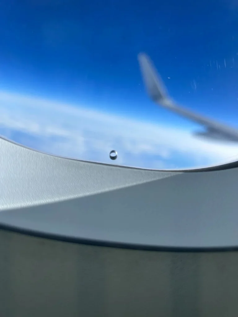 Why does every airplane window have a tiny hole in it?