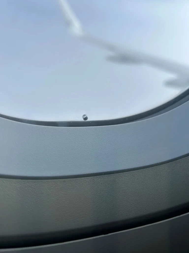 Why does every airplane window have a tiny hole in it?