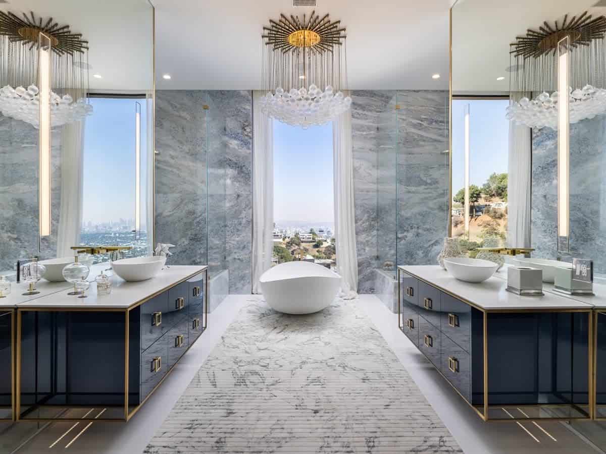 The opulent bathroom with a chandelier and a bathtub looking over LA inside 1 Bode Drive.