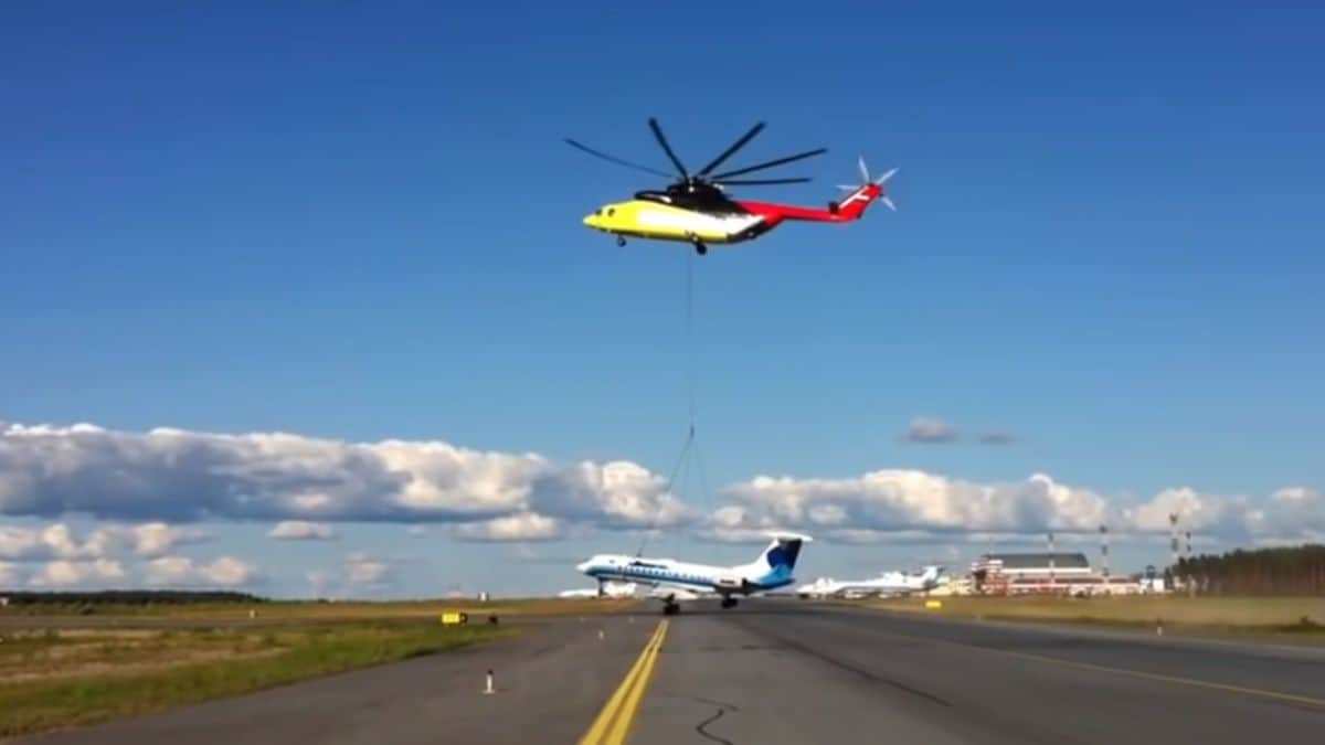 A Mil Mi-26 helicopter lifts a plane