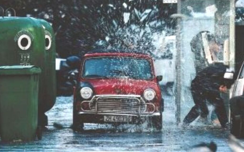 A red Mini drives down a sidewalk in The Bourne Identity. 