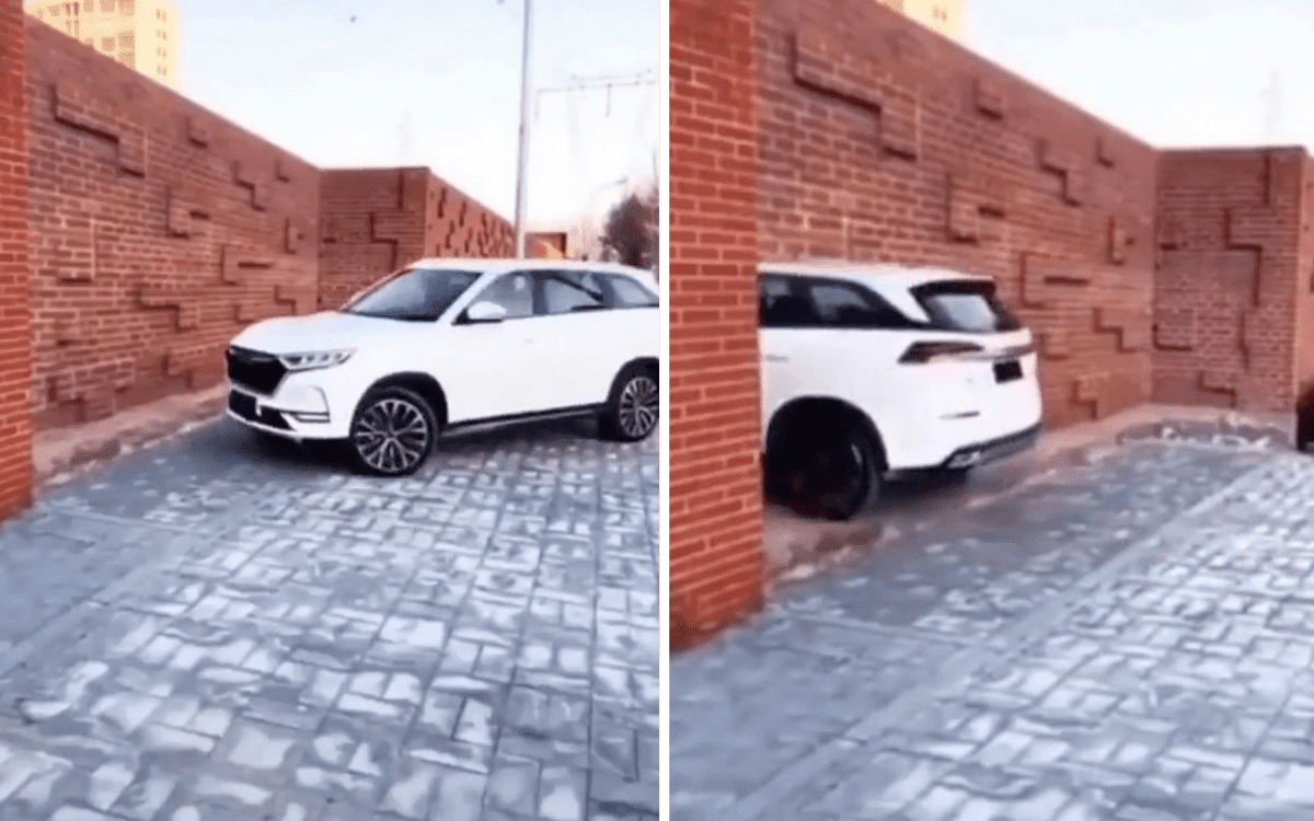A car appears to drive through a brick wall in an optical illusion.