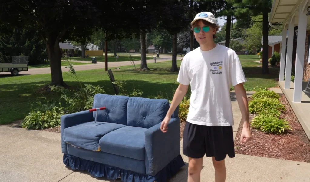 Man crashes a car meet by driving a fully functional, motorized living room couch and immediately upsets a Porsche owner