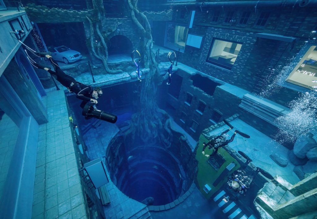 A diver hovers over a tunnel at the world's deepest pool, Deep Dive Dubai.
