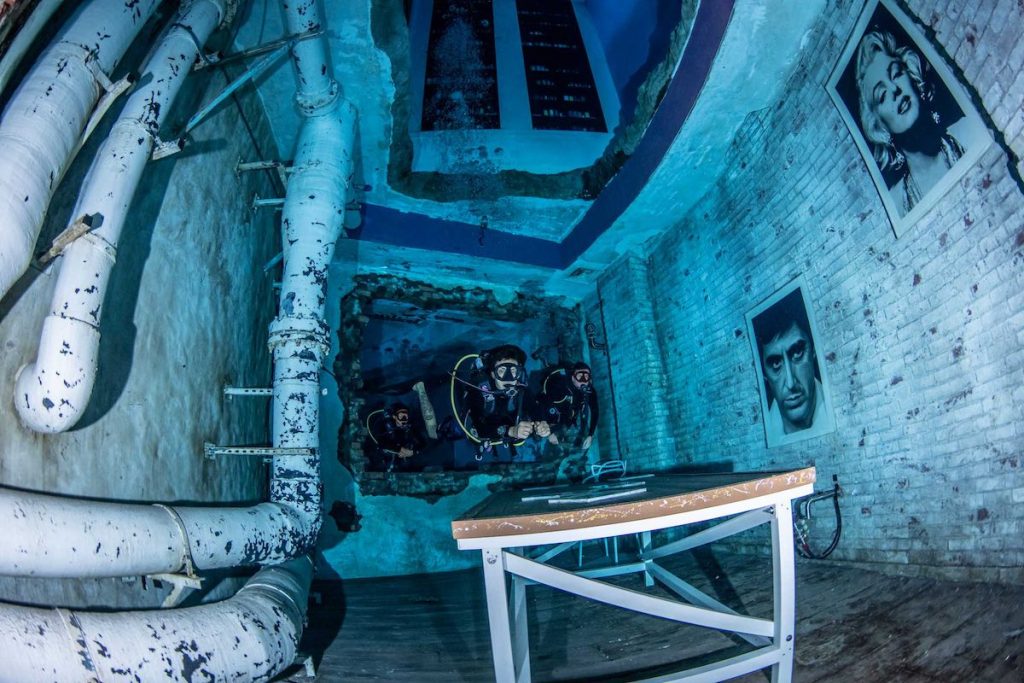 Photos of Al Pacino and Marilyn Monroe watch over two divers in the world's deepest pool.