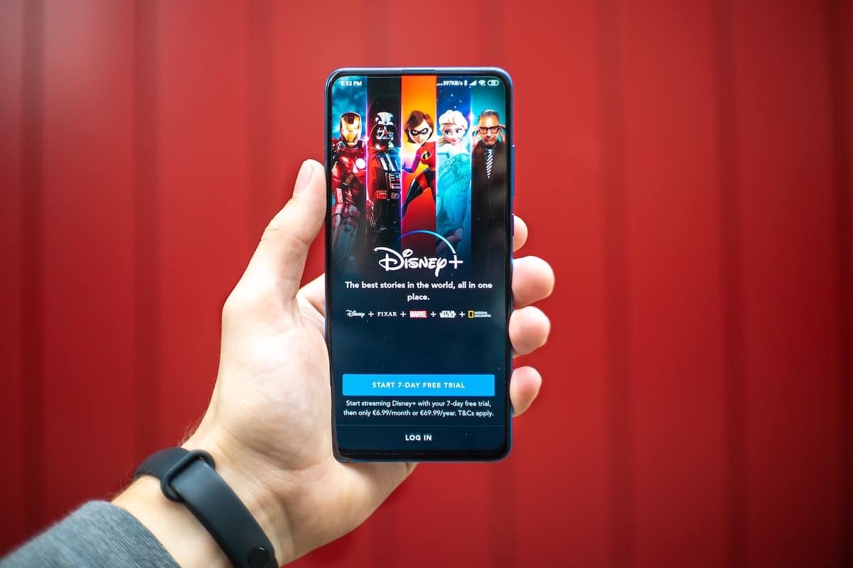 Hand holding phone with Disney+ app open