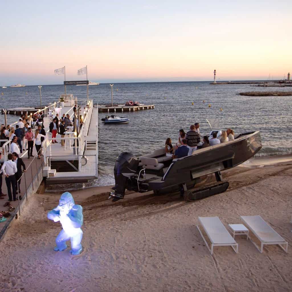 Iguana amphibious boat sits on the sand at a party 