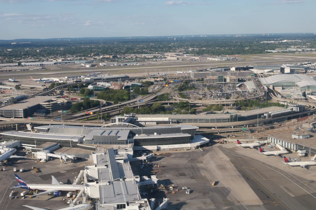 At JFK airport, cars drive under the tarmac while jets taxi overhead