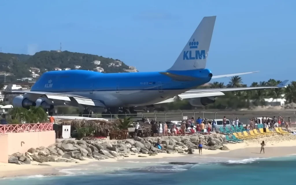 Boeing 747 jet blast on runway is so close to beach that it ends up blowing some people away