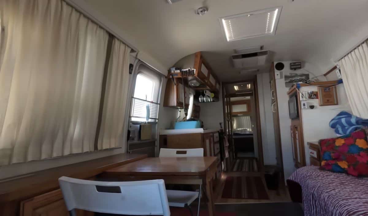 The cabin connects to the Airstream trailer through a small walkway