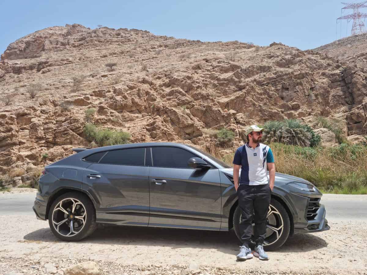 Brandon Livesay leans on the Lamborghini Urus in Tiwi, Oman.