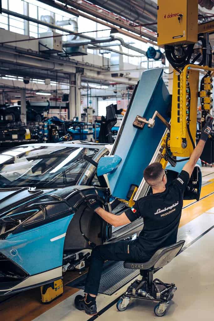 Factory worker fitting the door to a Lamborghini Aventador