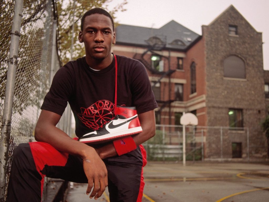 Michael Jordan posing with a pair of Air Jordans