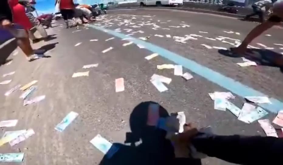 Cash flies out of motorcyclist's backpack in the Philippines