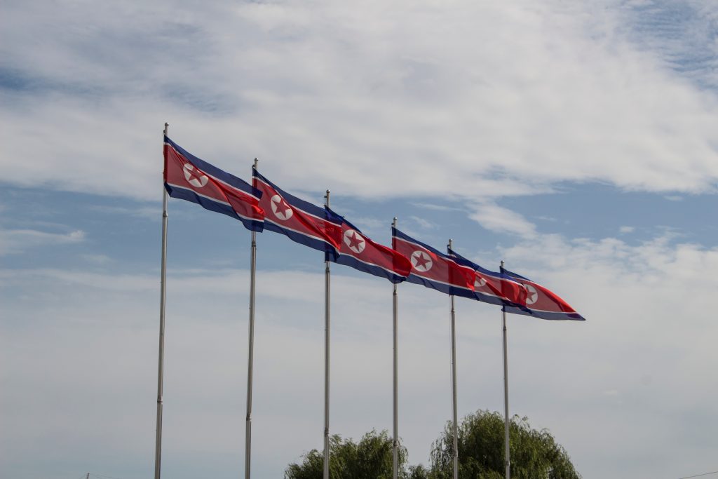 North Korea flags are pictured flying on flag poles.