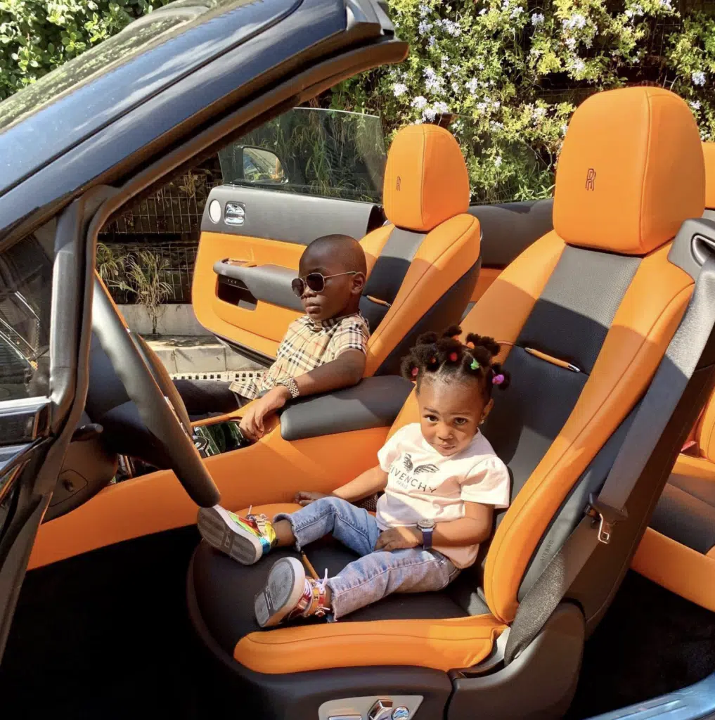 The 'world's youngest millionaire' loves posing with his dad's car despite not being old enough to drive them