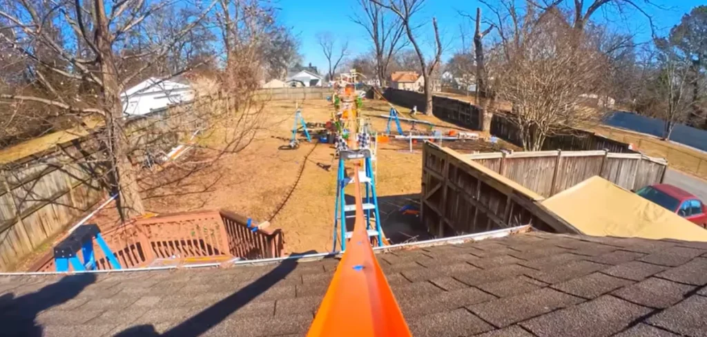 Someone built a 12-foot-tall Hot Wheels track that starts on a roof and uses water, lifts, and buckets to keep a tiny car moving through an entire backyard