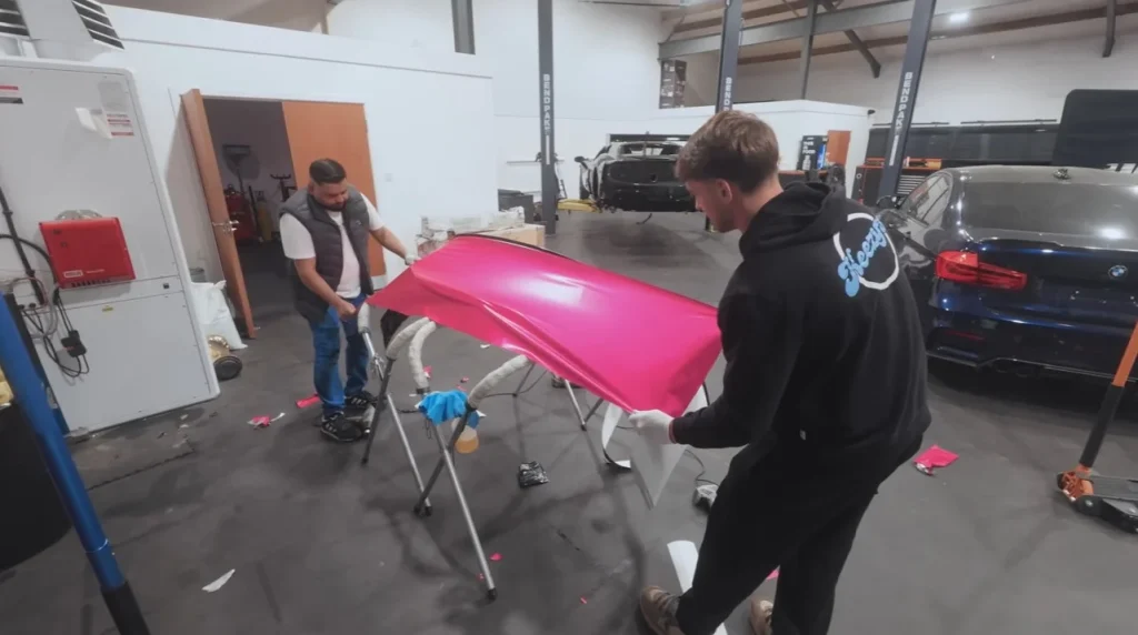 Mat Armstrong watches as a vibrant pink car wrap transforms a white vehicle during an intense 13-hour session inside his workshop to meet a midnight deadline