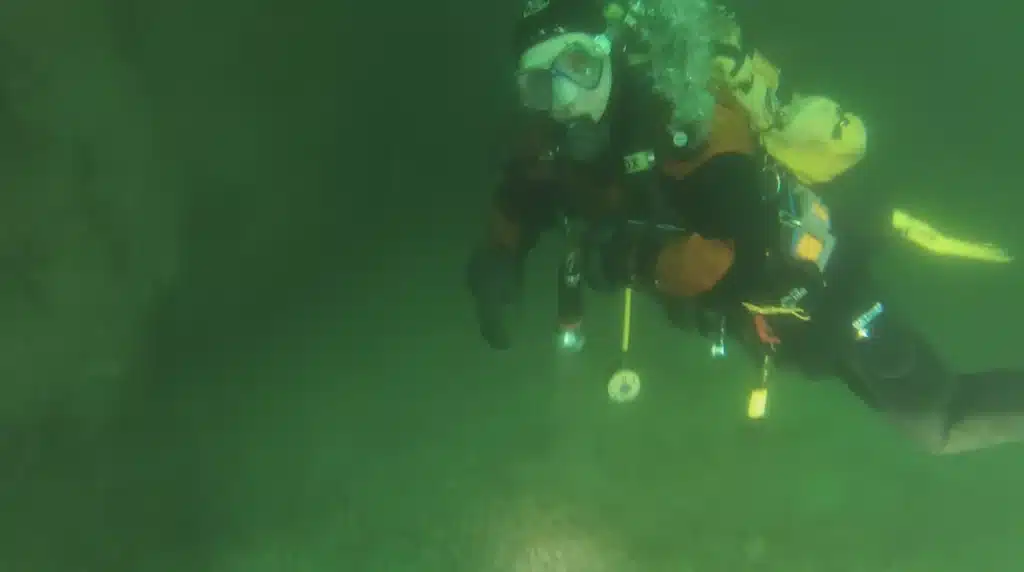 Diver exploring car graveyard in Italian lake