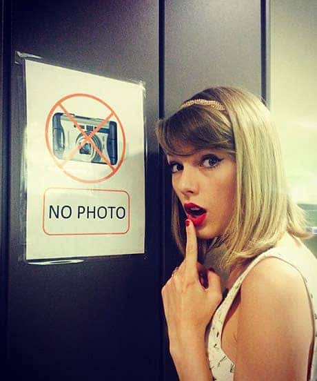 Taylor Swift next to 'no photo' sign