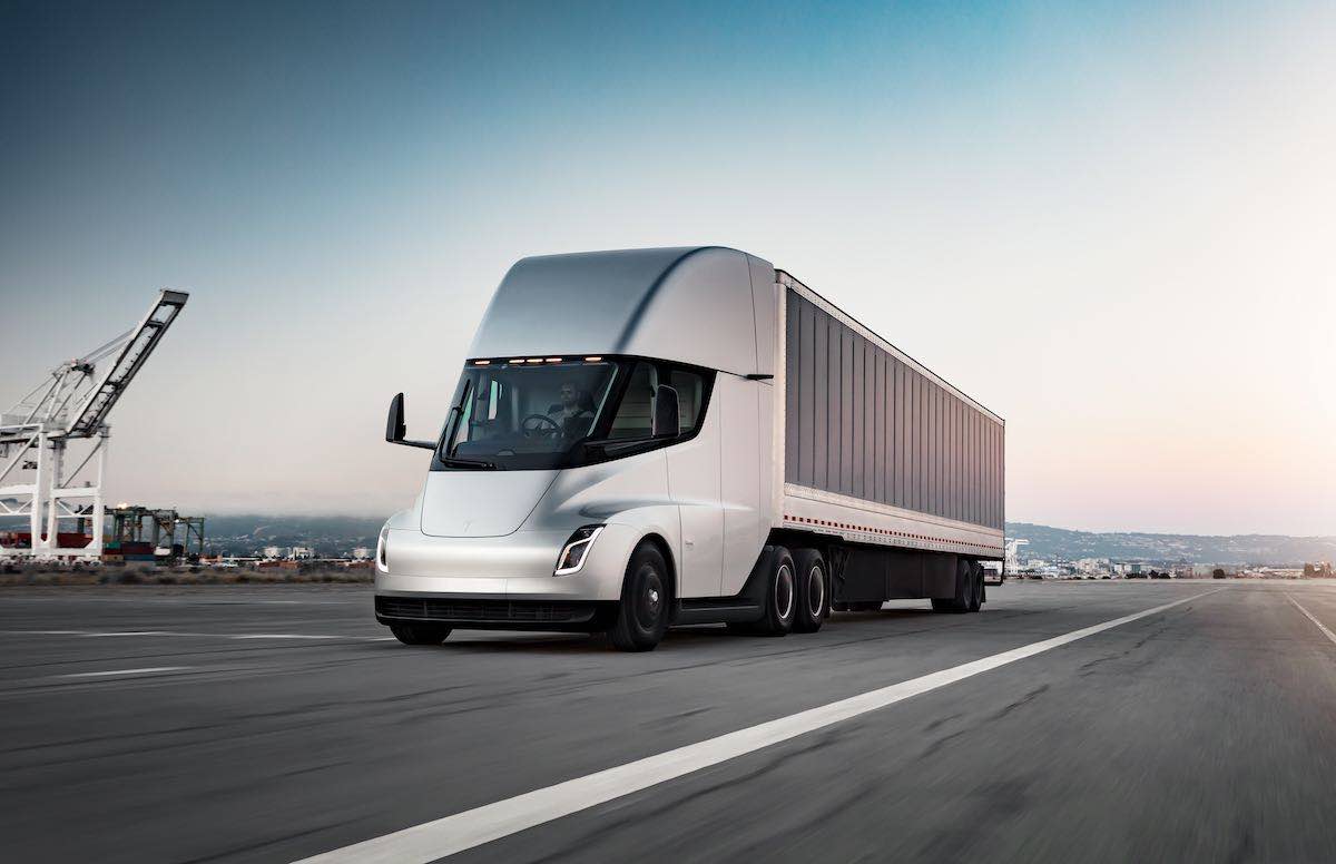 Tesla Semi driving on road with a trailer.