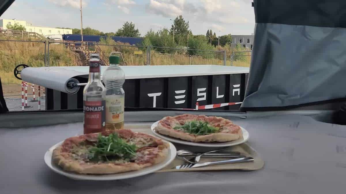 Eating pizza in a cafe by the Tesla swimming pool at charging station in Germany