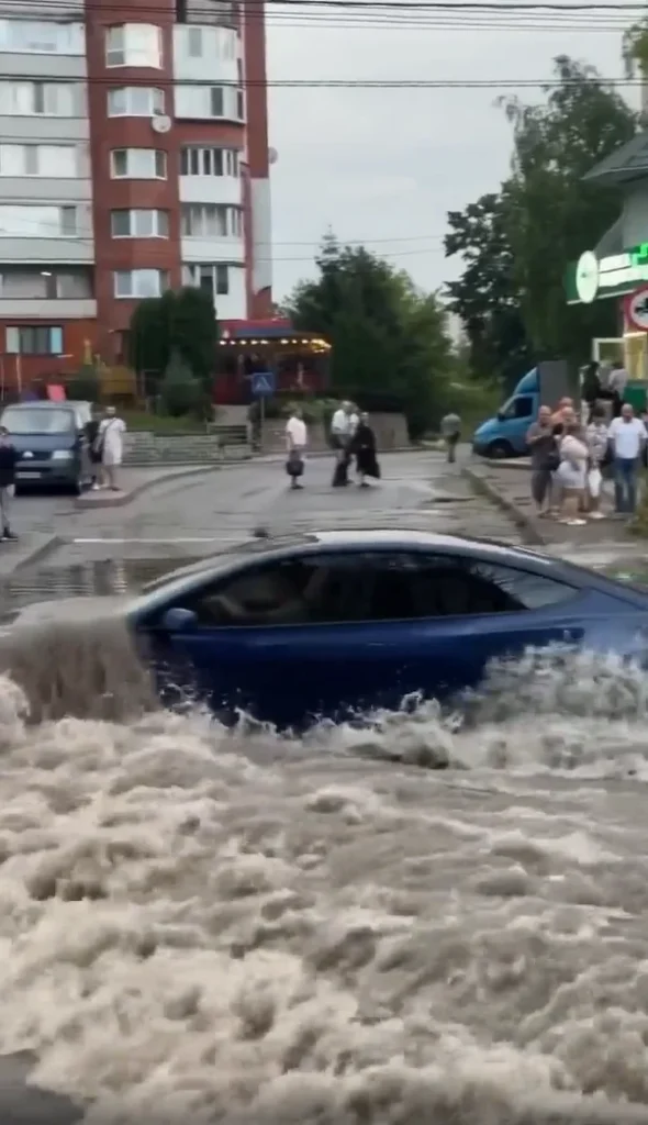 Tesla Model 3 spotted driving through a completely flooded street and it's definitely not something you'd see every day