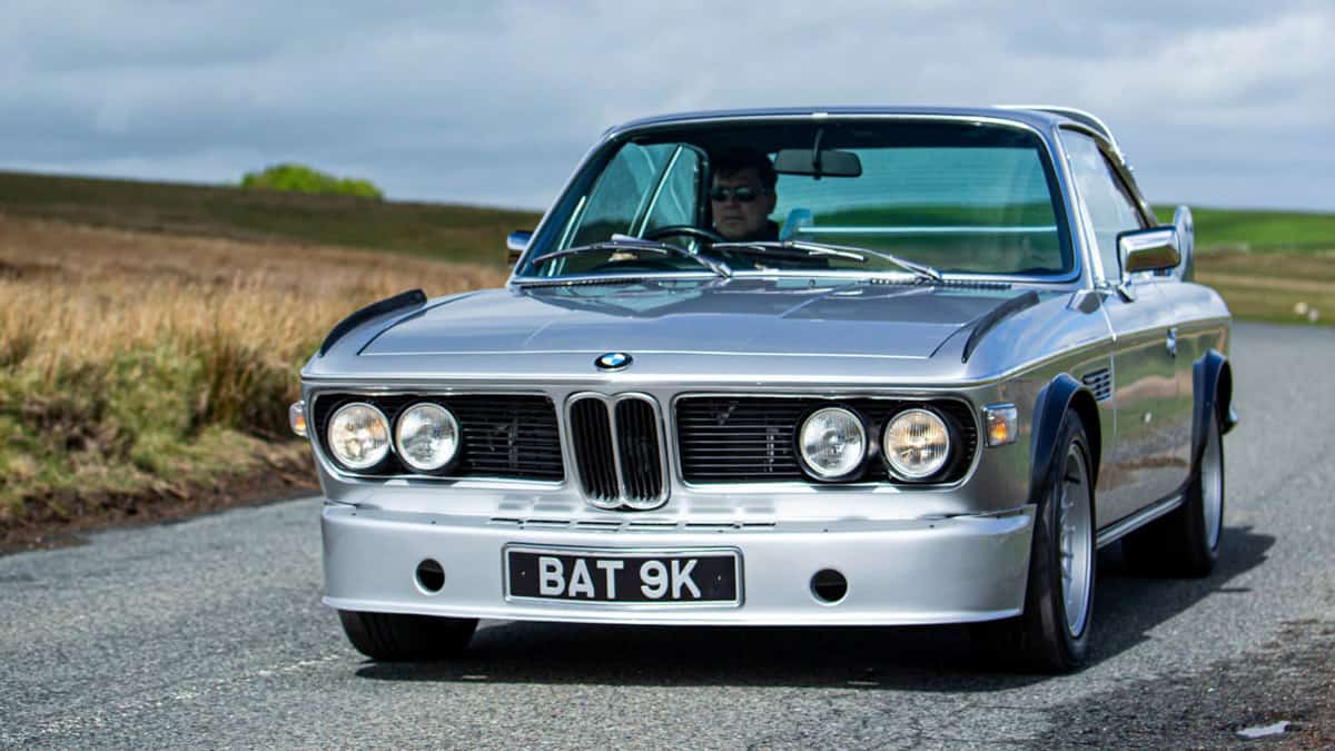 Front view of a BMW E9 Batmobile driving down the road
