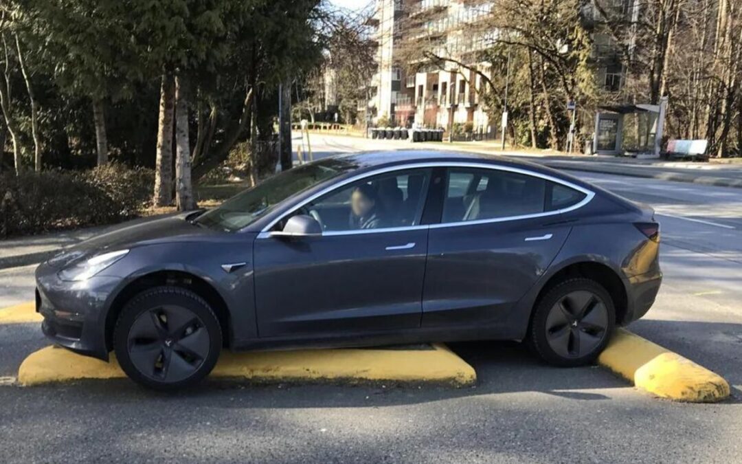 Embarrassed driver turtles her Tesla Model 3 on concrete lane divider
