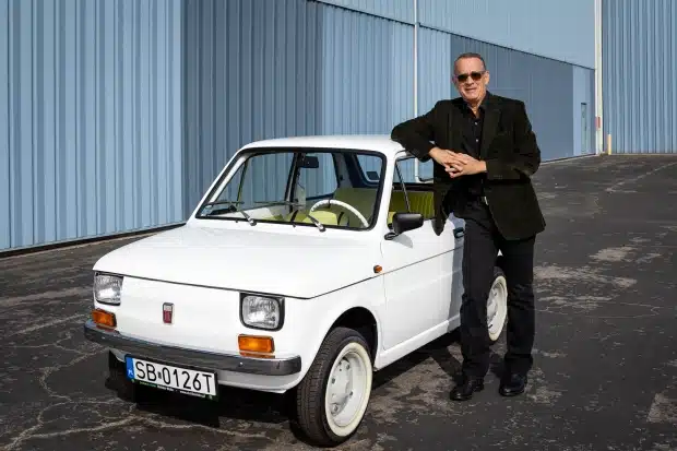 Tom Hanks standing next to his Fiat 126p