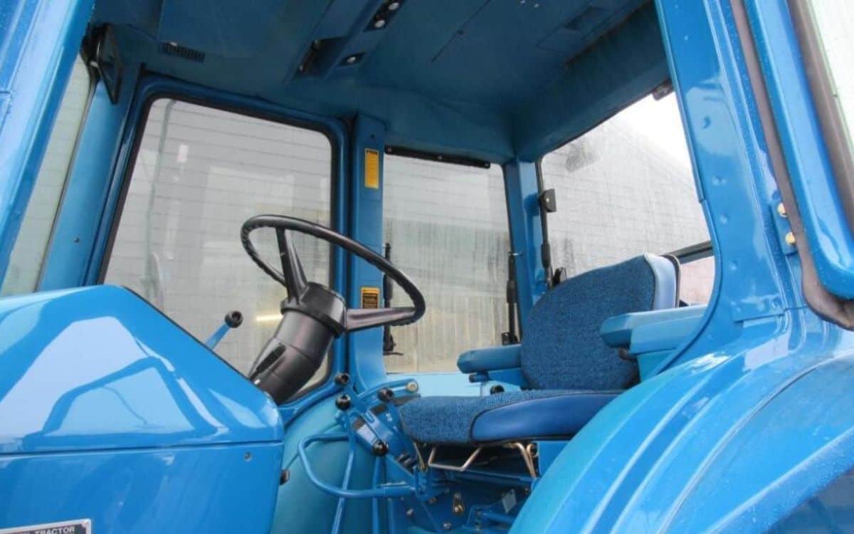 The seat and steering wheel inside the tractor.