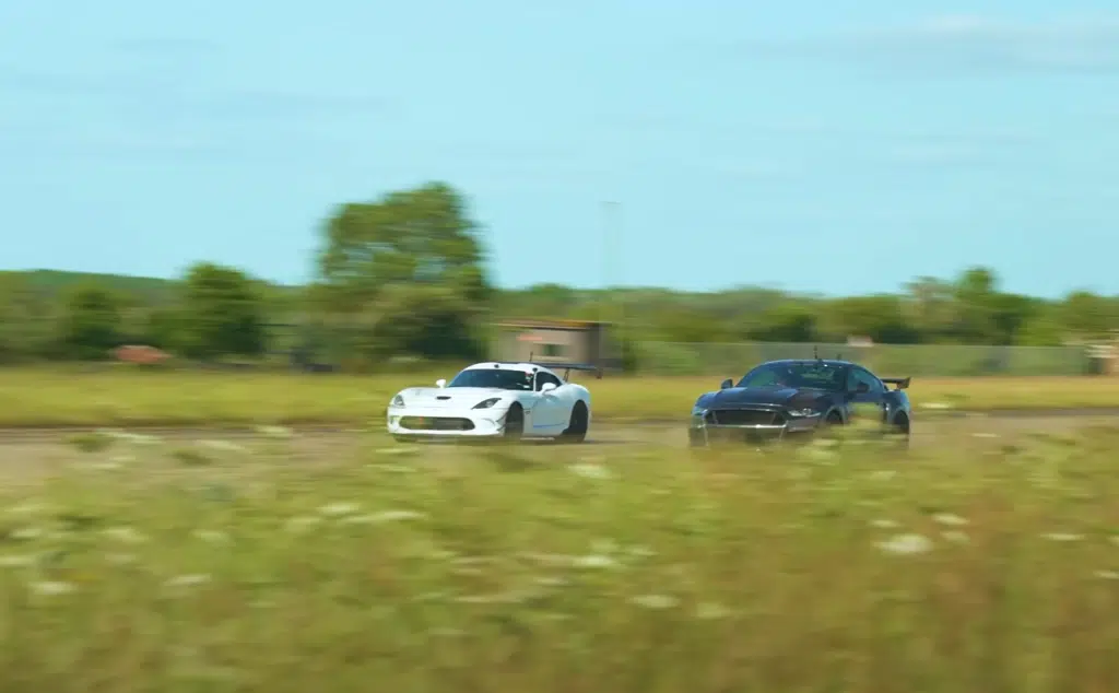 A supercharged Ford Mustang faces a Dodge Viper in a tuned V8 drag race, testing torque, weight, and real-world performance across multiple formats