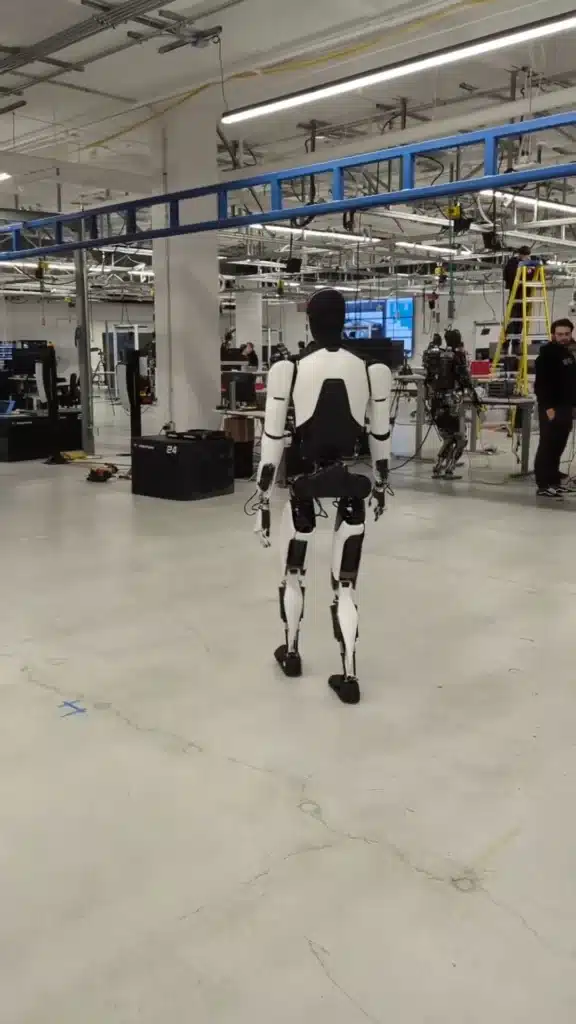 Optimus robot strolling confidently around lab