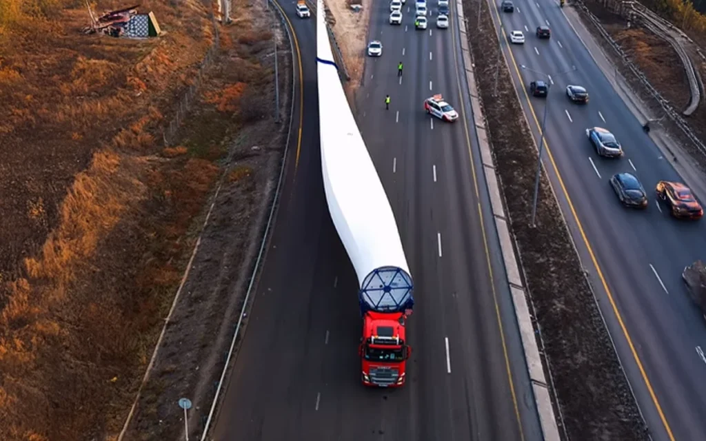 Drone footage has showcased how moving a single wind turbine turns the highway into a full-scale operation with five colossal lorries halting traffic