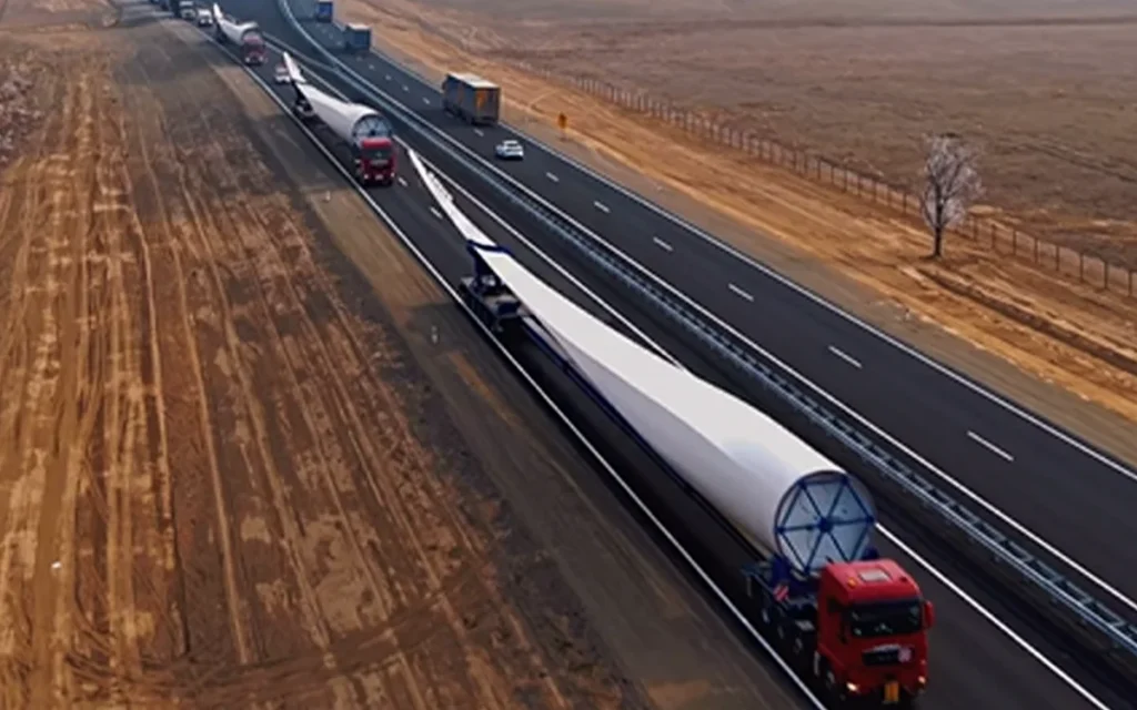 Drone footage has showcased how moving a single wind turbine turns the highway into a full-scale operation with five colossal lorries halting traffic