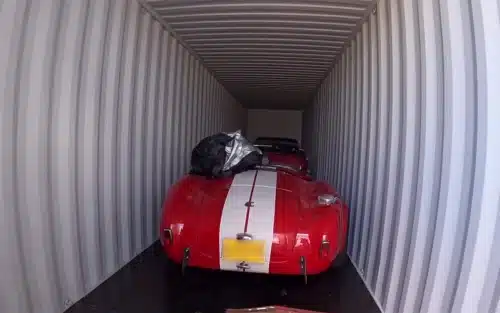 AC Cobra muscle car in a shipping container