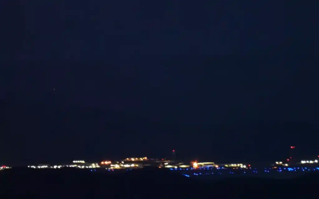Washington YouTuber Johnny Harris road-trips to Area 51, hikes Tikaboo Peak, and captures jets, midnight runway lights, and a mystery fly-by - but no UFO