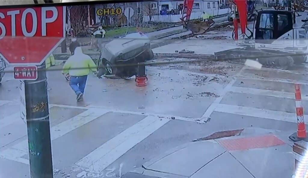 Car drives straight into a construction site and into a hole